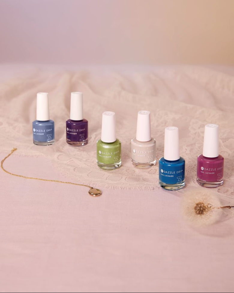 Set of nail polish bottles on a textured surface with a soft background